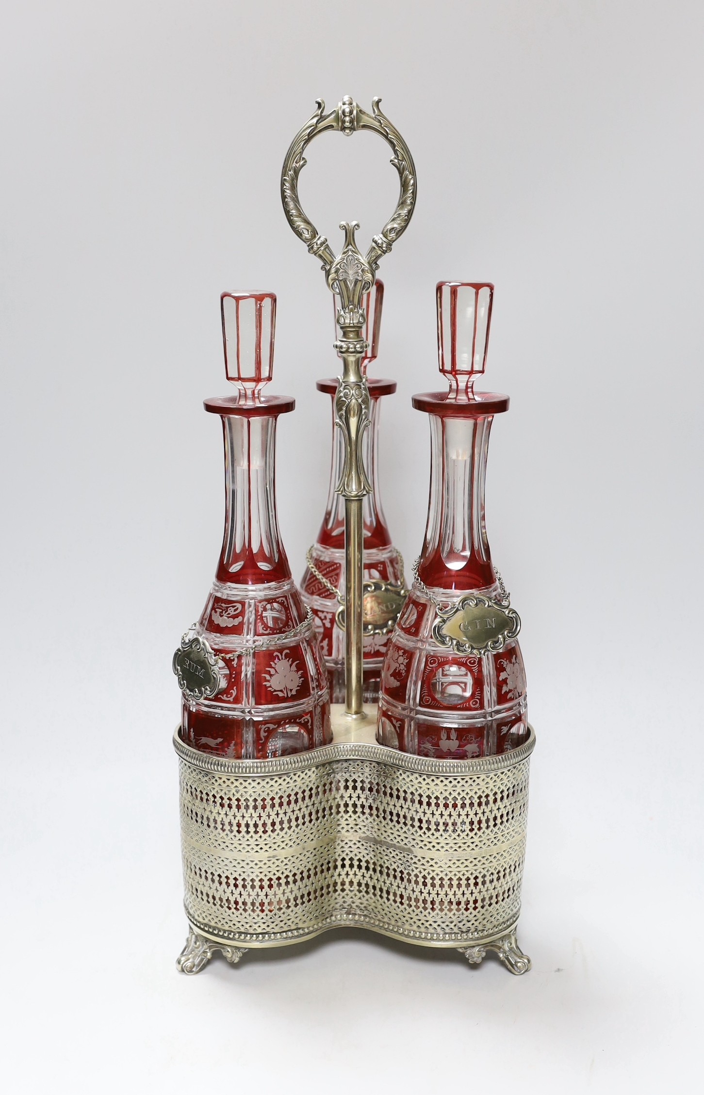 A Victorian three bottle ruby flashed glass and electroplate decanter stand, overall 46cms high